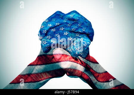 Les mains jointes d'un jeune homme de race blanche, avec le drapeau des États-Unis sur un fond blanc, avec une vignette ajouté Banque D'Images