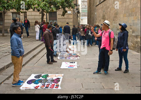 Colporteurs vendant marchandises bon marché pour les touristes sur rue dans Barcelone Espagne ES EU Banque D'Images