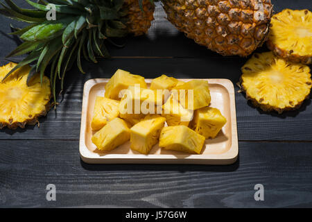 Concept de fruits tropicaux. Ananas coupés sur le vieux fond de bois. Banque D'Images