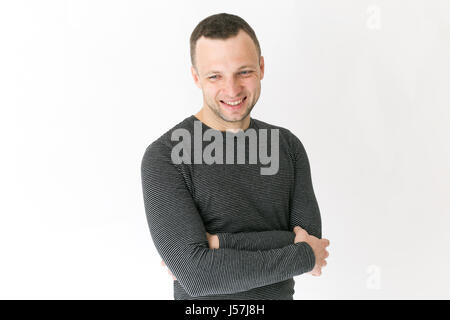 Studio portrait of smiling young man standing européen adultes près de mur blanc Banque D'Images