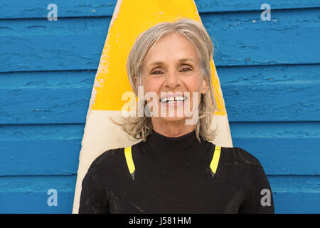 Portrait of smiling senior woman standing against blue hut Banque D'Images