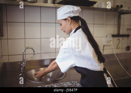 Femme chef lave-mains dans le restaurant à cuisine commerciale Banque D'Images