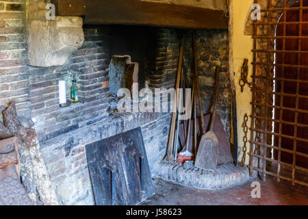 Ancienne cuisine avec cheminée et porte grille en fer Banque D'Images