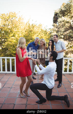 Homme Femme proposant en balcon à la maison Banque D'Images