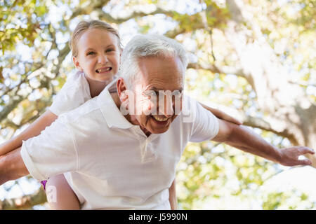 Grand-père-fille souriante donnant à dos dans la forêt Banque D'Images