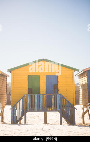 Cabane de plage sur le sable jaune contre ciel clair Banque D'Images