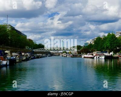 Bassin de l'arsenal avec la Colonne de Juillet, Colonne de Juillet, dans la distance et un pont pour piétons à l'avant-plan. Paris France Banque D'Images