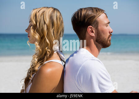 Close up of couple sitting at beach sur sunny day Banque D'Images