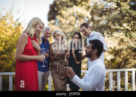 Homme Femme proposant en balcon à la maison Banque D'Images