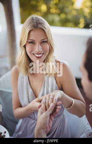 Man putting bague de fiançailles sur restaurant dans la main de femme Banque D'Images