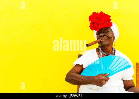 La femme cubaine avec cigare dans la bouche de poser pour les touristes à gagner de l'argent pour des photos Cuba La Havane femme posant cigare avec ventilateur Caraïbes femme Banque D'Images