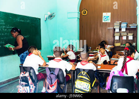 L'École de Cuba Cuba La Havane Cuba primary school teacher writing on blackboard à l'école enfants enseignant regarder d'enseigner aux enfants à l'école tableau Banque D'Images