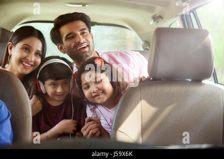 Happy Family sitting in back seat à la fenêtre de la voiture de Banque D'Images