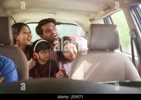 Happy Family sitting in back seat à la fenêtre de la voiture de Banque D'Images