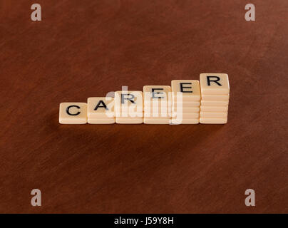 Carte avec des mots Carrière. Concept d'escalier de carrière. Carreaux ivoire avec des lettres majuscules sur l'acajou. Banque D'Images