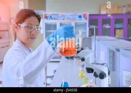 Avec de jeunes scientifiques d'exemple de substance dans la main travaillant dans un laboratoire de sciences Banque D'Images