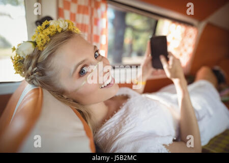 Portrait of smiling young woman using phone in van Banque D'Images