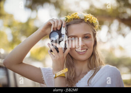 Portrait of smiling young woman holding camera Banque D'Images