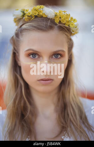 Portrait de jeune femme aux cheveux blonds portant des fleurs Banque D'Images