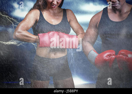 Portrait of male and female boxers avec des gants contre les éclaboussures de poudre de couleur jaune Banque D'Images