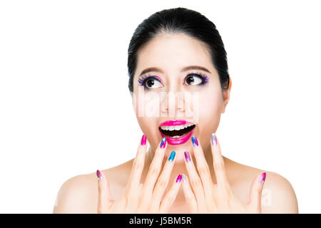 Modèle féminin excité montrer ses ongles couleur du dégradé près de lèvre rouge vif d'ouvrir la bouche et les yeux se concentrer sur fond blanc avec copyspace. Banque D'Images