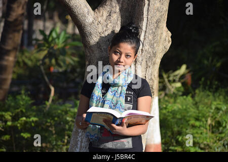 Jeune étudiante qui étudient à l'extérieur dans le jardin, Pune, Maharashtra Banque D'Images