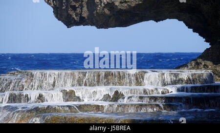 La plate-forme de roche à la plage cachée, Saipan l'eau coule sur la plate-forme de roches ressemblant à des escaliers Banque D'Images