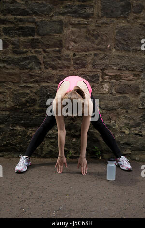 Athletic woman stretching avant ou après la formation. Concept d'action et d'un style de vie sain. Banque D'Images