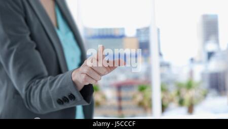 Digital composite de Midsection of businesswoman touching screen Banque D'Images