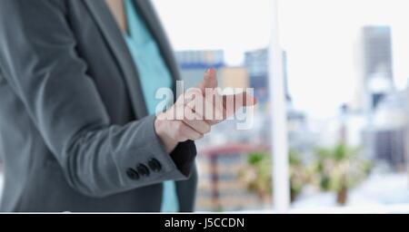 Digital composite de Midsection of businesswoman touching screen Banque D'Images