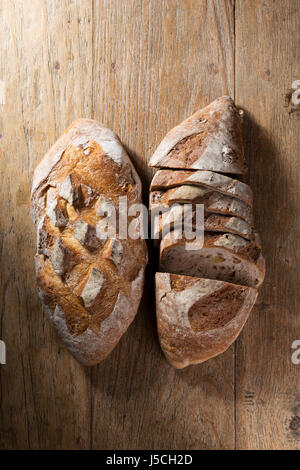 Voir ci-dessus de deux loafs rustique de pain sur une vieille table en bois. Banque D'Images