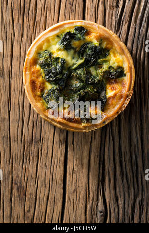 Quiche aux épinards faites maison. La nourriture est assis sur un fond de bois rustique. Banque D'Images