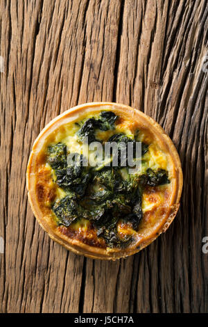 Quiche aux épinards faites maison. La nourriture est assis sur un fond de bois rustique. Banque D'Images