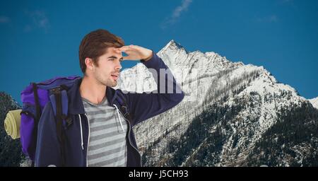 Digital composite d'hommes blindage voyageur sac à dos tout en portant les yeux sur la montagne Banque D'Images