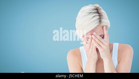 Digital composite of Woman crying in hands against blue background Banque D'Images