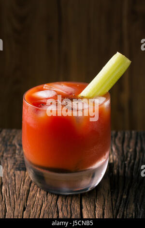 Un cocktail bloody mary assis sur une barre en bois rustique. Banque D'Images