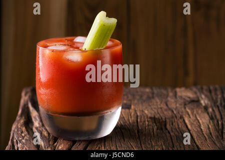 Un cocktail bloody mary assis sur une barre en bois rustique. Banque D'Images