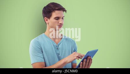 Digital composite of Young man using tablet computer sur fond vert Banque D'Images