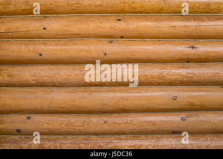 Mur en bois d'une maison de bois. Log Cabin ou dans un bâtiment non écorcées texturé mur arrière-plan horizontal avec l'exemplaire de l'espace. Banque D'Images