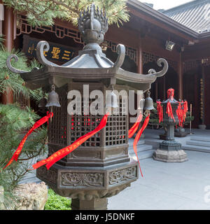 Brass lantern avec drapeaux de prière rouge attaché au temple du Bouddha de Jade à Shanghai Banque D'Images