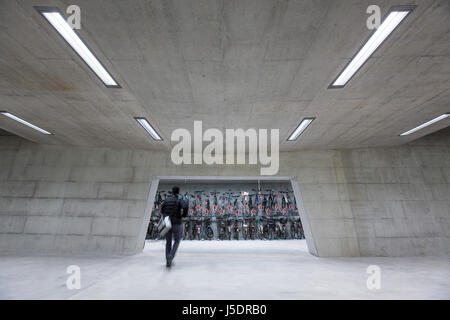 La gare moderne avec bikestands - ruée vers l'homme qui marche pour obtenir son vélo et trajet de retour (tons de couleur libre;motion image floue) Banque D'Images