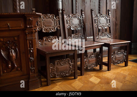 Chaises en bois dans l'ancienne salle de billard de la Villa Kramář (Kramářova vila) à Prague, République tchèque. La villa conçue par l'architecte autrichien Friedrich Ohmann 1911-1914 a été construit pour l'homme politique tchèque Karel Kramář et sa femme Russe Nadezhda Kramář, née Khludova. La salle de billard a été décoré en style russe. Le bâtiment est aujourd'hui a été la résidence officielle du Premier Ministre de la République tchèque. Banque D'Images