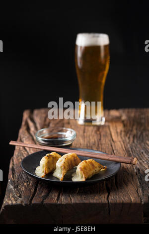 Une assiette de raviolis gyoza japonais assis sur une table en bois rustique. Banque D'Images