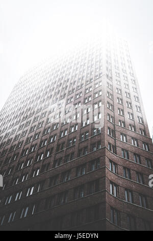 La façade de l'immeuble de grande hauteur dans le brouillard brumeux - brique skyscraper Banque D'Images