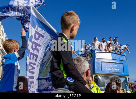 Les jeunes Brighton et Hove Albion Football Fans Watch que le bus de l'équipe passe au cours de la promotion du Club Parade, Brighton, Sussex, UK Banque D'Images