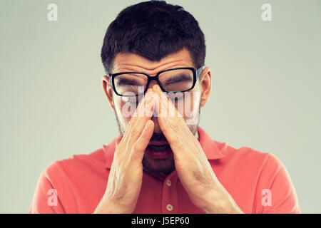 Lunettes homme fatigué en se frottant les yeux Banque D'Images