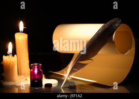 Vintage nature morte au pot d'encre et plume près de faire défiler sur fond sombre avec des bougies Banque D'Images
