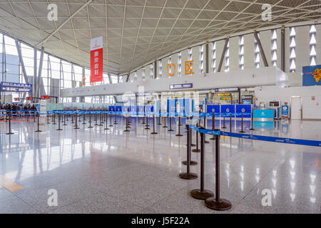 Urumqi, Chine, le 28 octobre 2016 Fonction publique : La zone d'enregistrement avec les barrières de contrôle des foules de la ville à l'aéroport tôt le matin et le temps. Banque D'Images