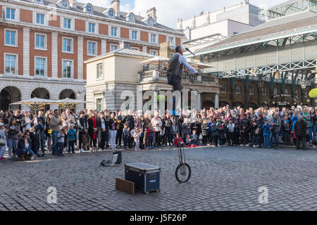 Les touristes à regarder un spectacle de rue à Covent Garden Market à Londres Banque D'Images