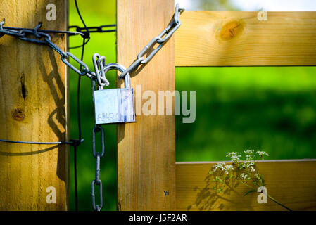 La sécurisation de la chaîne et cadenas barrière en bois à un poste. Banque D'Images